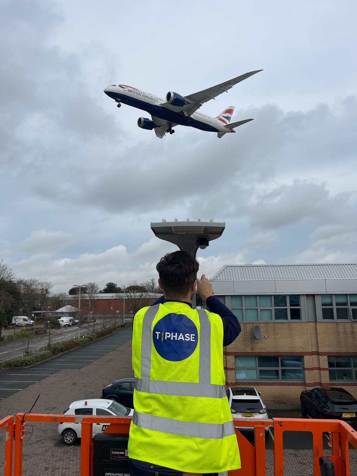 T Phase engineer installing car park floodlighting under the Heathrow flight path